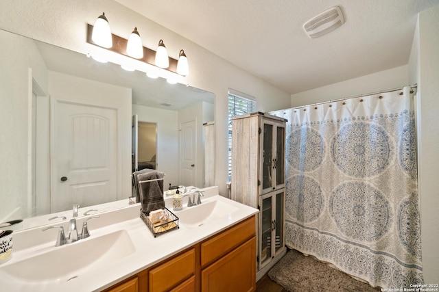 full bathroom featuring double vanity, visible vents, and a sink