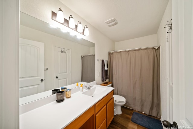 full bath with visible vents, curtained shower, wood finished floors, vanity, and toilet