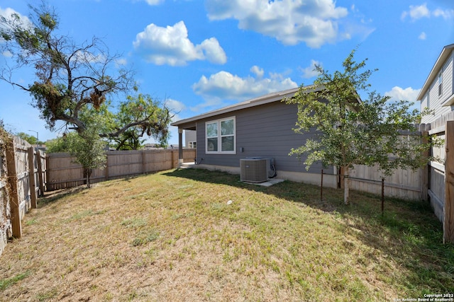 view of yard with a fenced backyard and central AC
