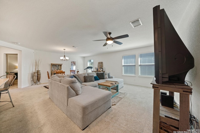 living room featuring visible vents, baseboards, ceiling fan with notable chandelier, and light carpet