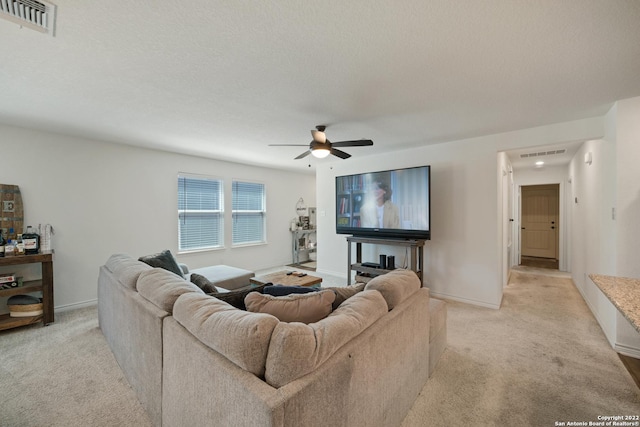 living room with ceiling fan, visible vents, and light carpet