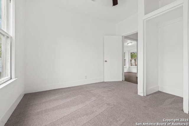 unfurnished bedroom featuring carpet floors, baseboards, and a ceiling fan