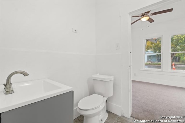 bathroom with vanity, baseboards, a ceiling fan, and toilet