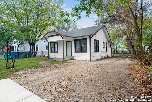 ranch-style house featuring a porch, fence, a front lawn, and dirt driveway