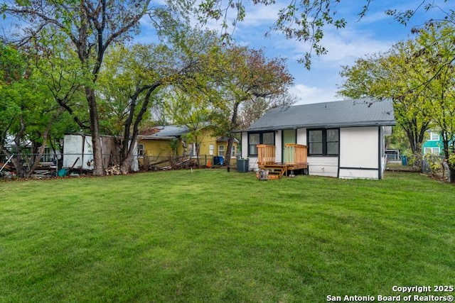 rear view of house featuring a lawn, fence, and central air condition unit