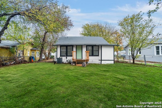 back of property with a yard, fence, and entry steps