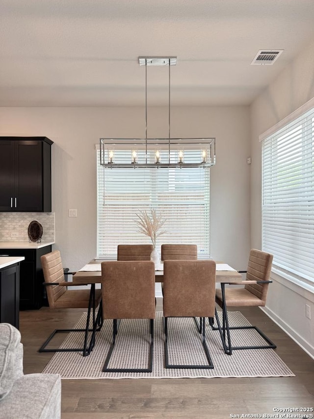 dining room featuring visible vents and dark wood-style flooring