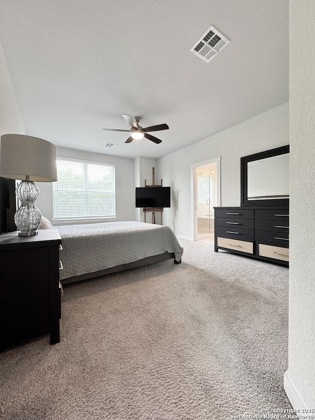 bedroom with carpet, a ceiling fan, connected bathroom, and visible vents
