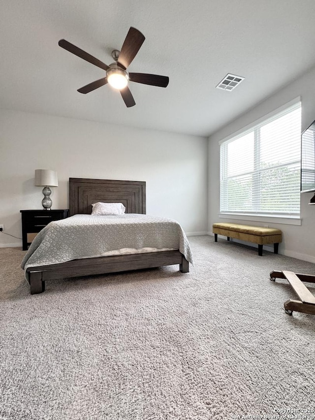 bedroom with carpet floors, a ceiling fan, and visible vents