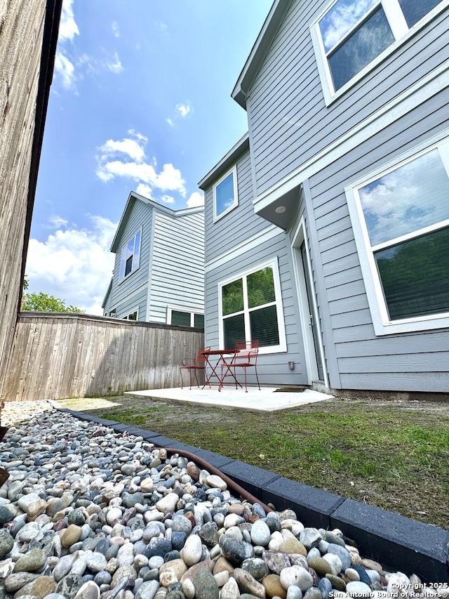 rear view of property with a yard, fence, and a patio area