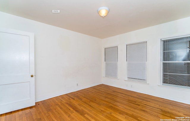 unfurnished room featuring baseboards and light wood-style flooring