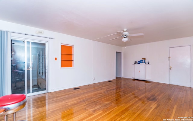 spare room featuring light wood-type flooring, ceiling fan, and visible vents