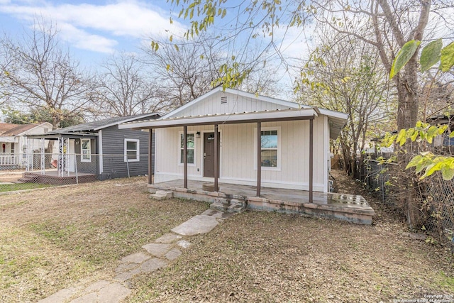 bungalow-style house with a porch and fence