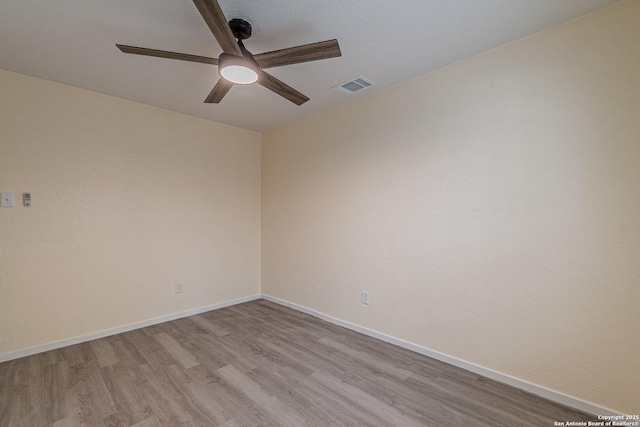 unfurnished room with light wood-style floors, baseboards, ceiling fan, and visible vents