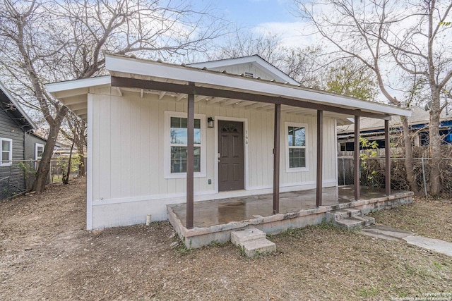 view of front of property with a porch and fence