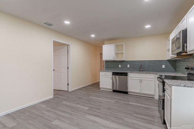 kitchen with white cabinets, open shelves, appliances with stainless steel finishes, and visible vents