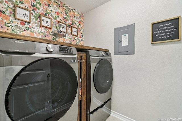 clothes washing area with washing machine and clothes dryer, laundry area, baseboards, and electric panel