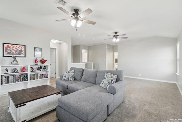 carpeted living area with visible vents, arched walkways, baseboards, and ceiling fan