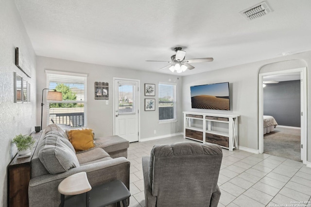 living area with a ceiling fan, baseboards, visible vents, and light tile patterned floors