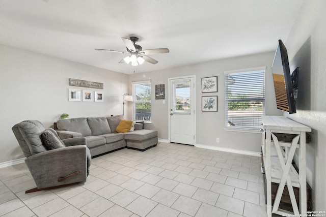 living room with baseboards, a ceiling fan, and light tile patterned floors