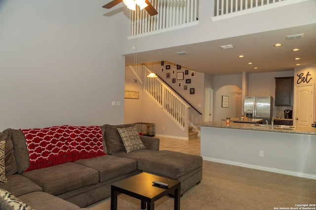 8220 Robin Gate, Selma, TX 78154 - living area featuring ceiling fan, a towering ceiling, visible vents, arched walkways, and stairs