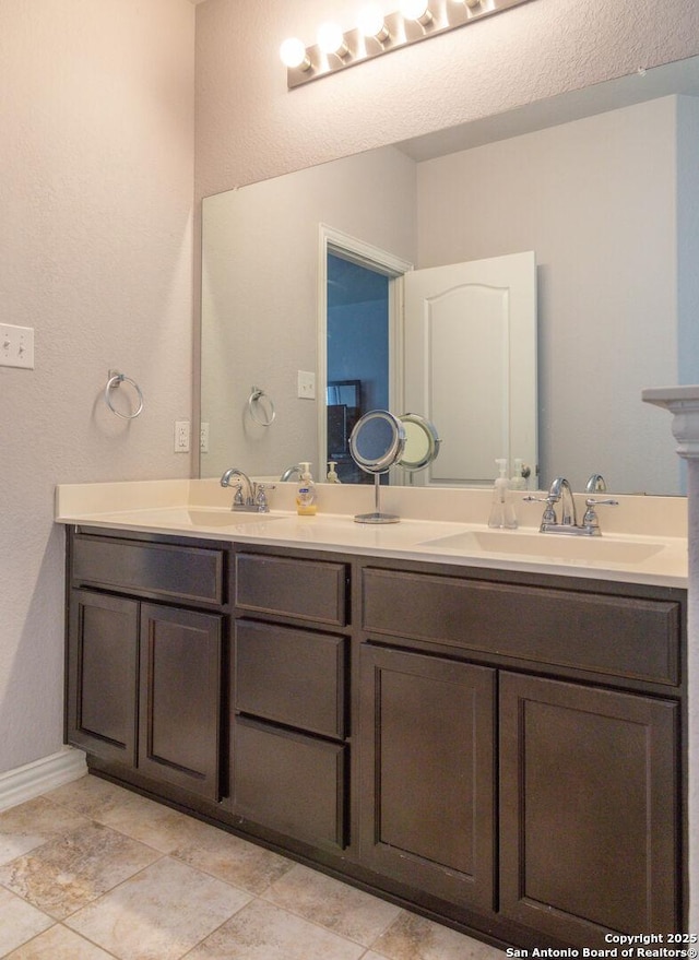 8220 Robin Gate, Selma, TX 78154 - full bath with baseboards, double vanity, a textured wall, and a sink