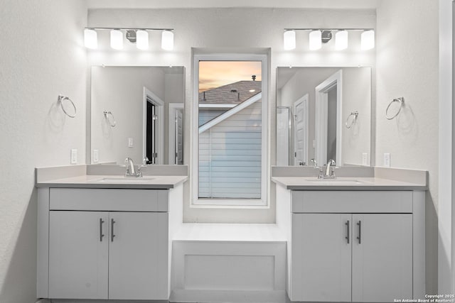 15011 Wychwood, San Antonio, TX 78233 - bathroom with a sink, a textured wall, and two vanities
