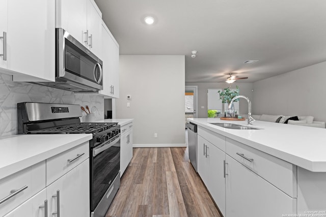 15011 Wychwood, San Antonio, TX 78233 - kitchen featuring ceiling fan, wood finished floors, a sink, light countertops, and stainless steel appliances