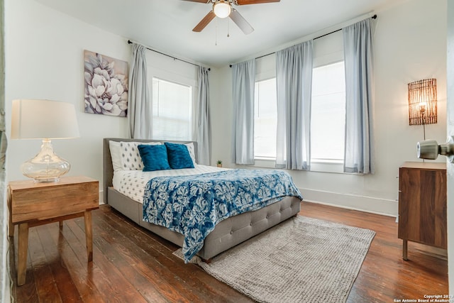 bedroom featuring wood-type flooring, a ceiling fan, and baseboards