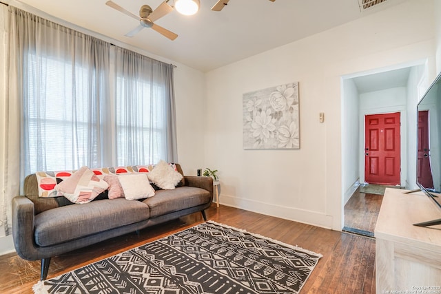 living area featuring baseboards, ceiling fan, wood finished floors, and visible vents