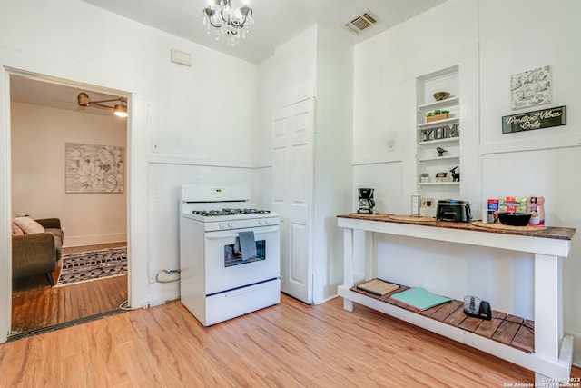 kitchen featuring visible vents, open shelves, white gas range oven, a notable chandelier, and light wood-style flooring