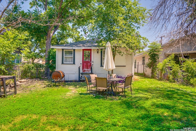 rear view of house featuring a lawn and a fenced backyard