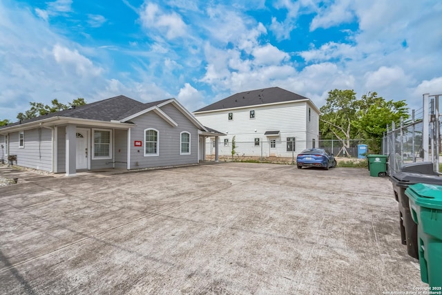 back of property featuring fence and driveway