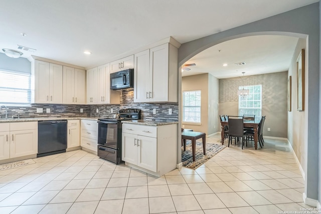 kitchen with visible vents, decorative backsplash, baseboards, and black appliances