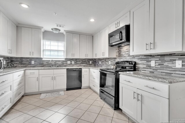 kitchen with visible vents, light tile patterned flooring, tasteful backsplash, a sink, and black appliances