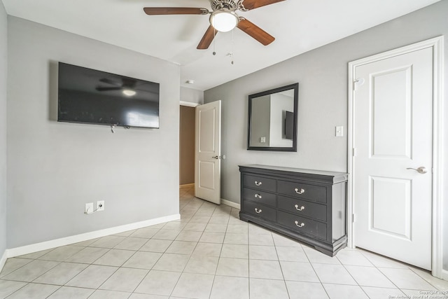 unfurnished bedroom with light tile patterned floors, baseboards, and a ceiling fan