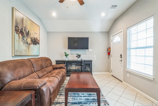 living area with ceiling fan, baseboards, light tile patterned floors, lofted ceiling, and visible vents