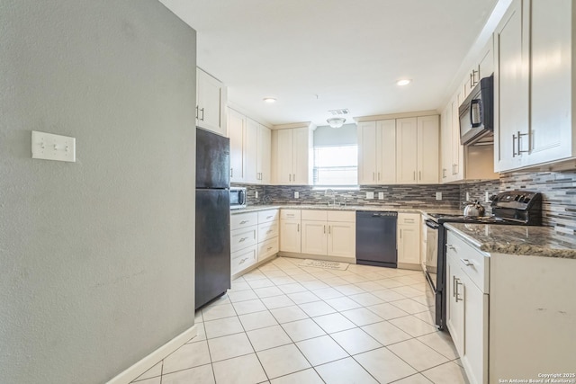 kitchen with tasteful backsplash, light tile patterned floors, black appliances, dark stone countertops, and a textured wall