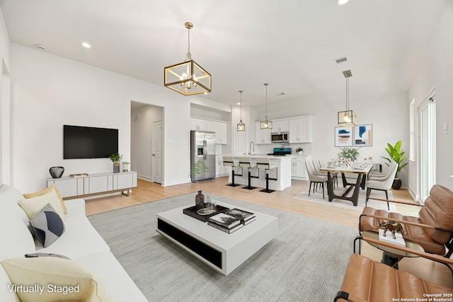 25 Main, Hempstead, TX 77445 - living area with visible vents, recessed lighting, light wood finished floors, and a chandelier