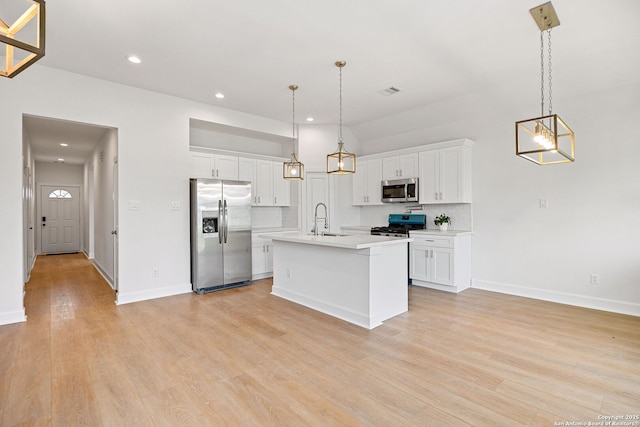 25 Main, Hempstead, TX 77445 - kitchen featuring light countertops, white cabinets, a sink, light wood-style flooring, and stainless steel appliances
