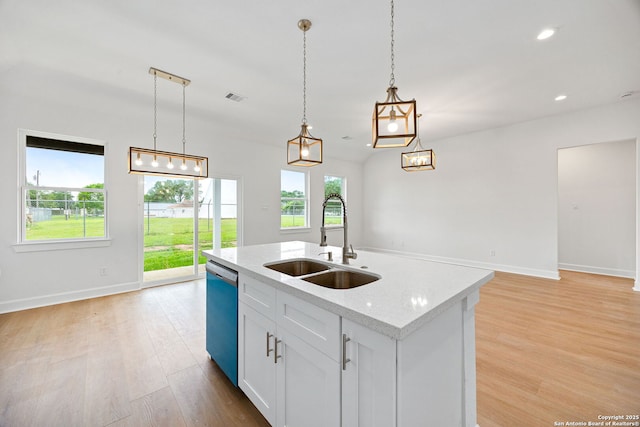 25 Main, Hempstead, TX 77445 - kitchen featuring light wood-style floors, baseboards, dishwashing machine, a center island with sink, and a sink