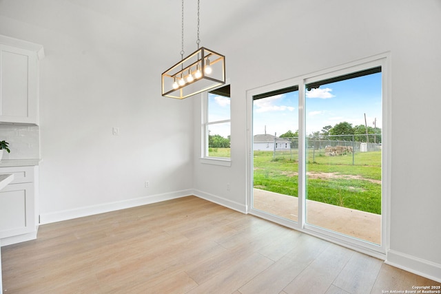 25 Main, Hempstead, TX 77445 - unfurnished dining area featuring baseboards, a chandelier, and light wood finished floors
