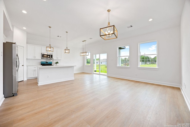 25 Main, Hempstead, TX 77445 - unfurnished living room with recessed lighting, baseboards, light wood-type flooring, and a chandelier
