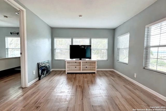 living area featuring baseboards and wood finished floors