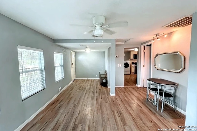 living room with baseboards, a ceiling fan, wood finished floors, and visible vents
