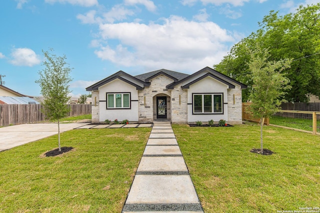 bungalow with fence, stone siding, stucco siding, and a front yard