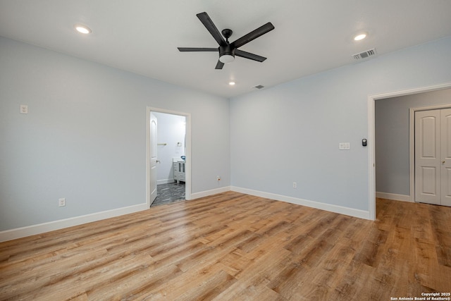 spare room with light wood-style floors, baseboards, a ceiling fan, and visible vents