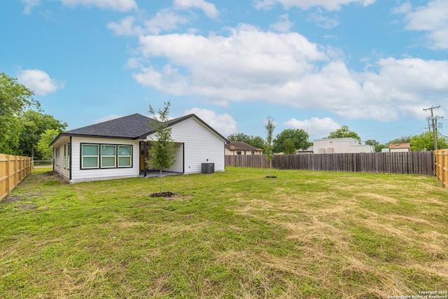 view of yard with a fenced backyard and central air condition unit