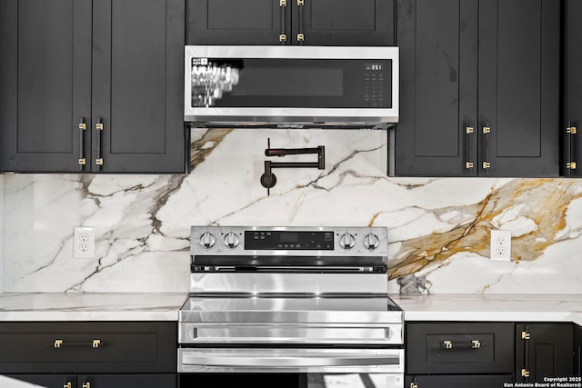 kitchen featuring dark cabinets, decorative backsplash, and stainless steel appliances