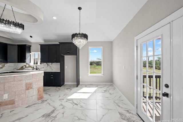 kitchen with dark cabinetry, light countertops, a chandelier, and a wealth of natural light